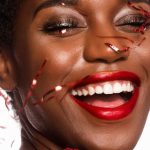 New Year - Close-up Photo of Smiling Woman with Her Eyes Closed Posing As Confetti Drops Down Her Face