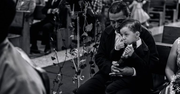Funeral Customs - A man and a boy are sitting in a church