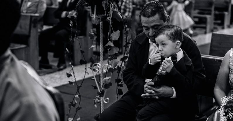 Funeral Customs - A man and a boy are sitting in a church