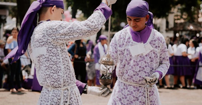 Traditional Dances - Two men in purple and white are holding a metal object