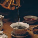 Tea Ceremony - Gold Kettle Pouring Hot Water on Cup of Tea