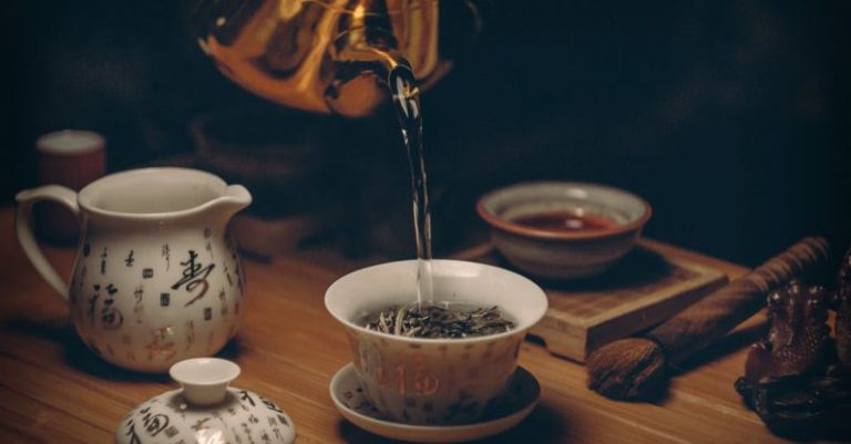 Tea Ceremony - Gold Kettle Pouring Hot Water on Cup of Tea