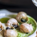 French Cuisine - High angle delicious escargots appetizer served on wooden board in fine dining French restaurant