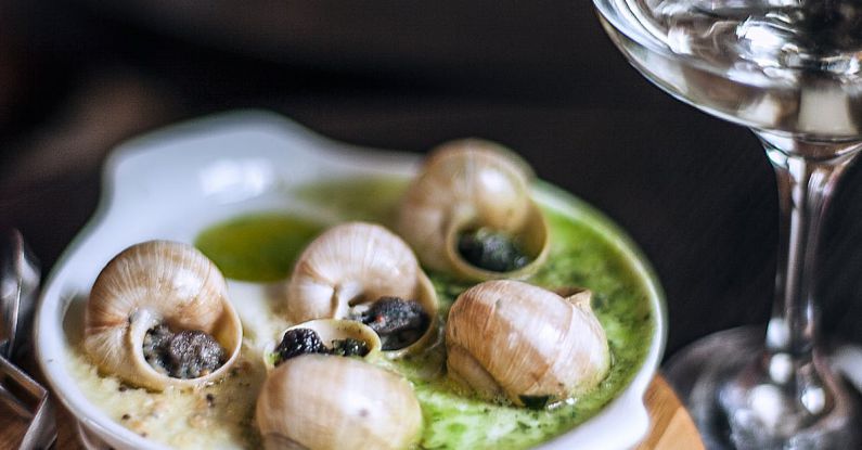 French Cuisine - High angle delicious escargots appetizer served on wooden board in fine dining French restaurant